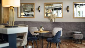 Un intérieur moderne avec une table ronde, deux chaises, un canapé et une petite table ronde.