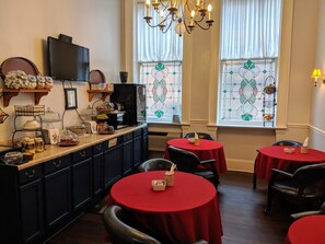 Enjoy meals in this classic dining area with a long counter, dark cabinets, and elegant stained glass windows.