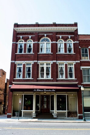 Experience the classic charm of this historic hotel, featuring a symmetrical facade with evenly spaced windows and decorative trim.
