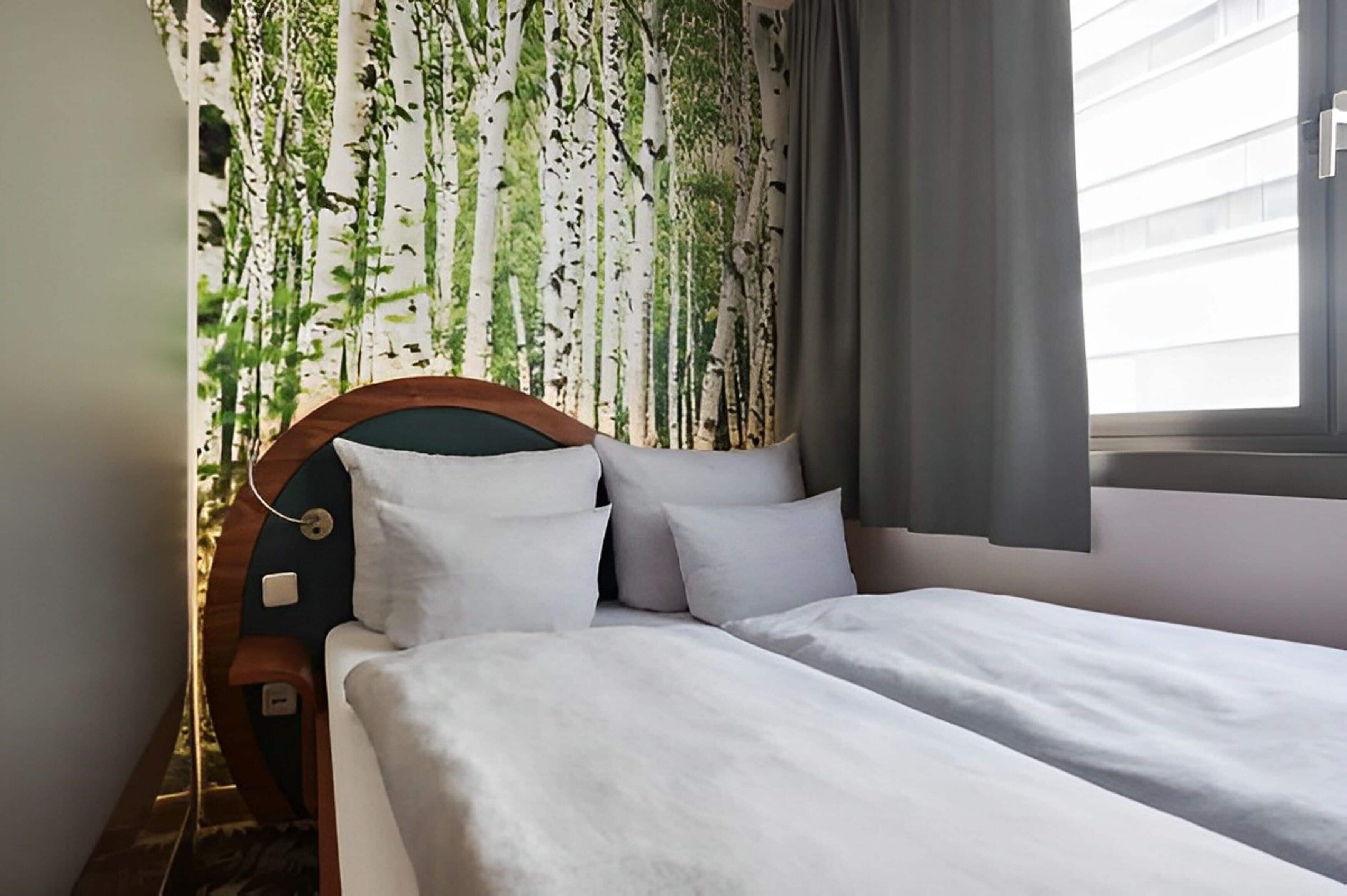 Un dormitorio con cama, cabecera y ventana con cortinas.