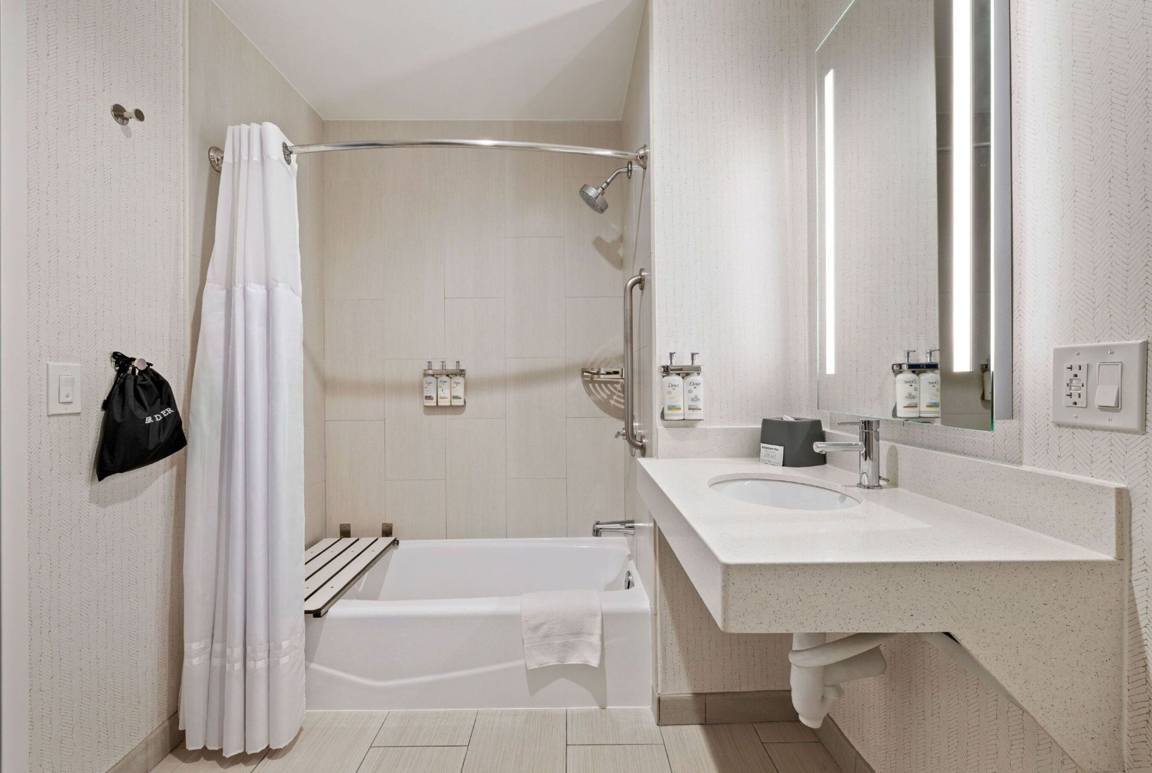 A modern bathroom with a bathtub, shower, and sink.