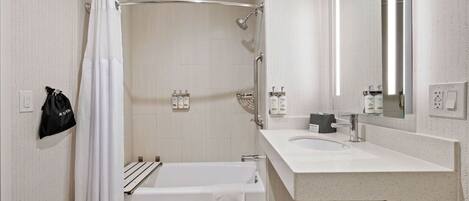 A modern bathroom with a bathtub, shower, and sink.