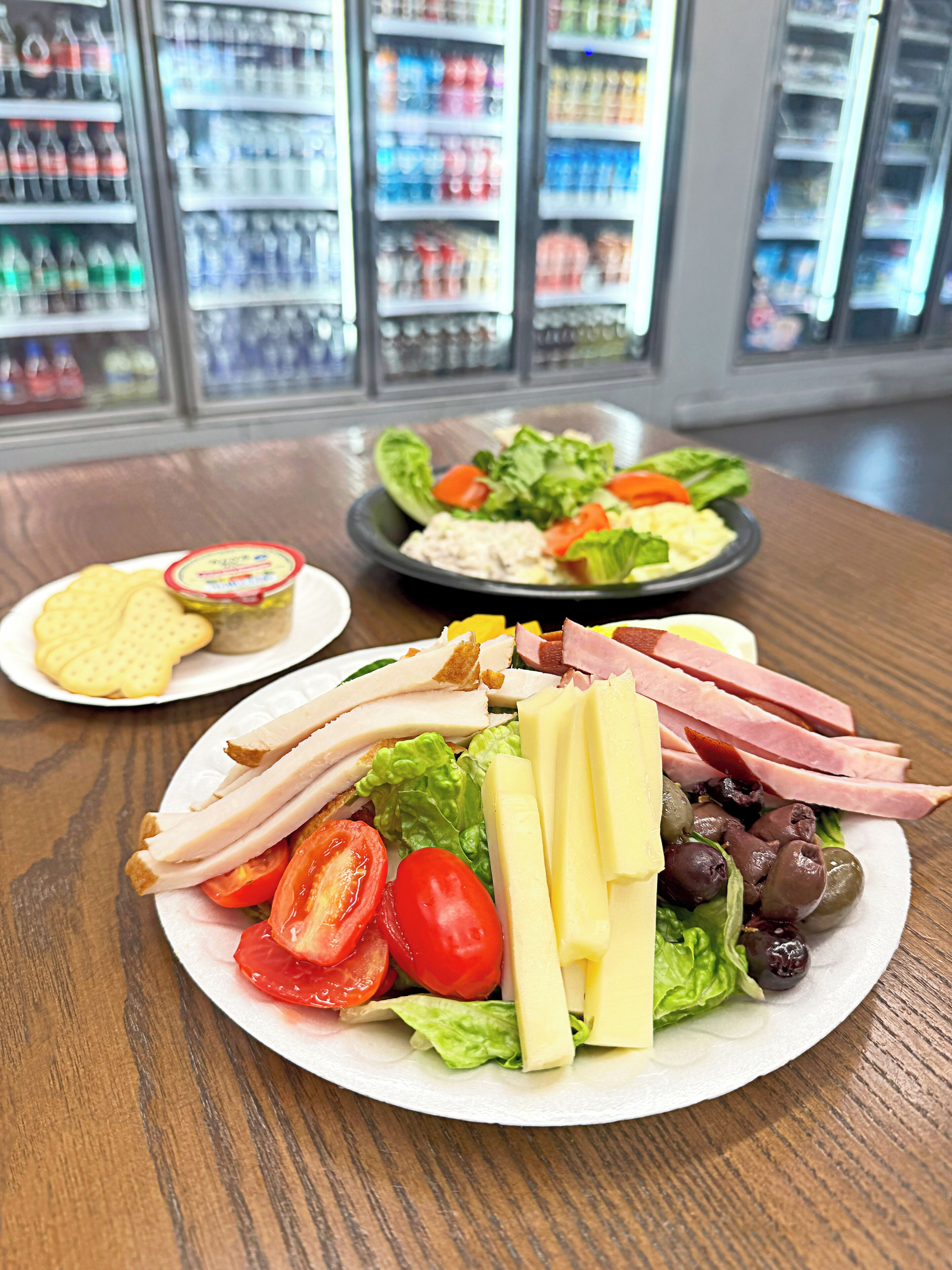 A meal with various food items on a table, with a refrigerator in the background.