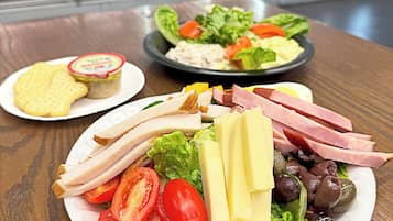 A meal with various food items on a table, with a refrigerator in the background.