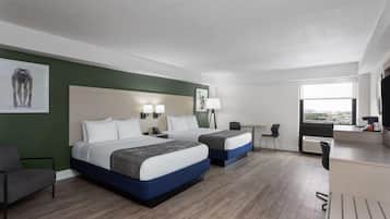 Een hotelkamer met twee bedden, een bureau, een stoel en een groot raam.