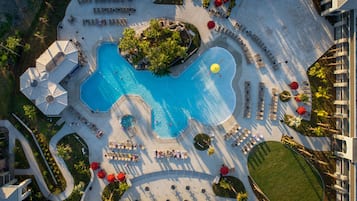 Alberca al aire libre, sombrillas en la alberca y camastros