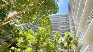 A high-rise building with multiple balconies, surrounded by lush greenery and palm trees. - Wyndham I-Drive Avanti Resort & Conference Center (Orlando)