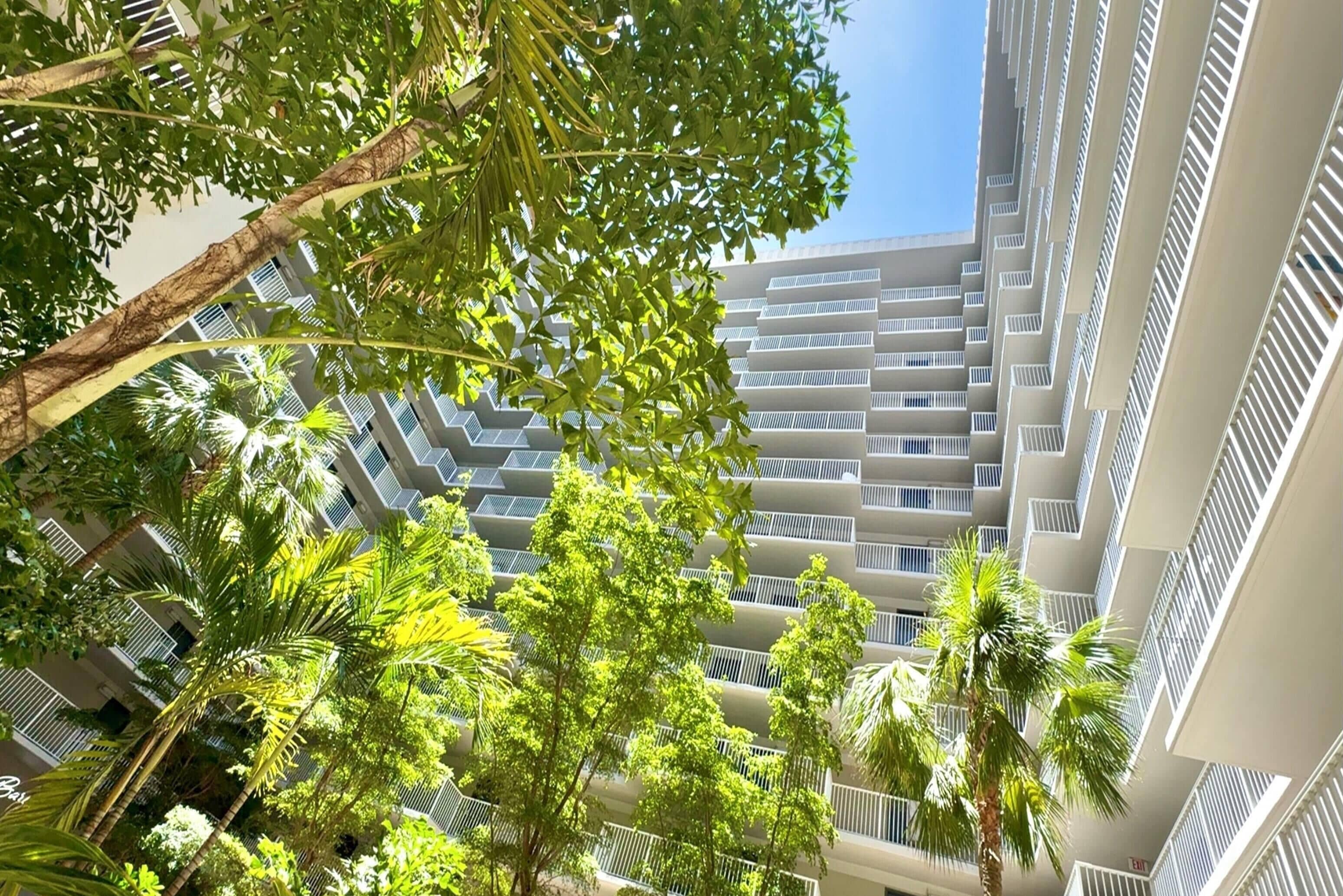 Un edificio de varios pisos con balcones y vista al cielo.