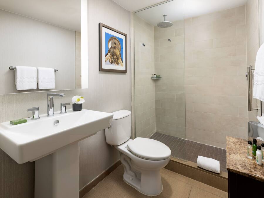 A modern bathroom with a sink, toilet, and shower.