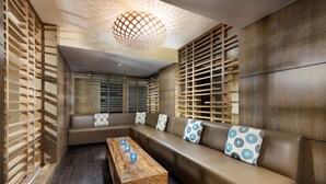 Un interior moderno con un sofá modular, paredes de listones de madera y una mesa de centro de madera.