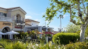 Un edificio con balcón, mesas al aire libre y un letrero que dice "SUGARFISH".