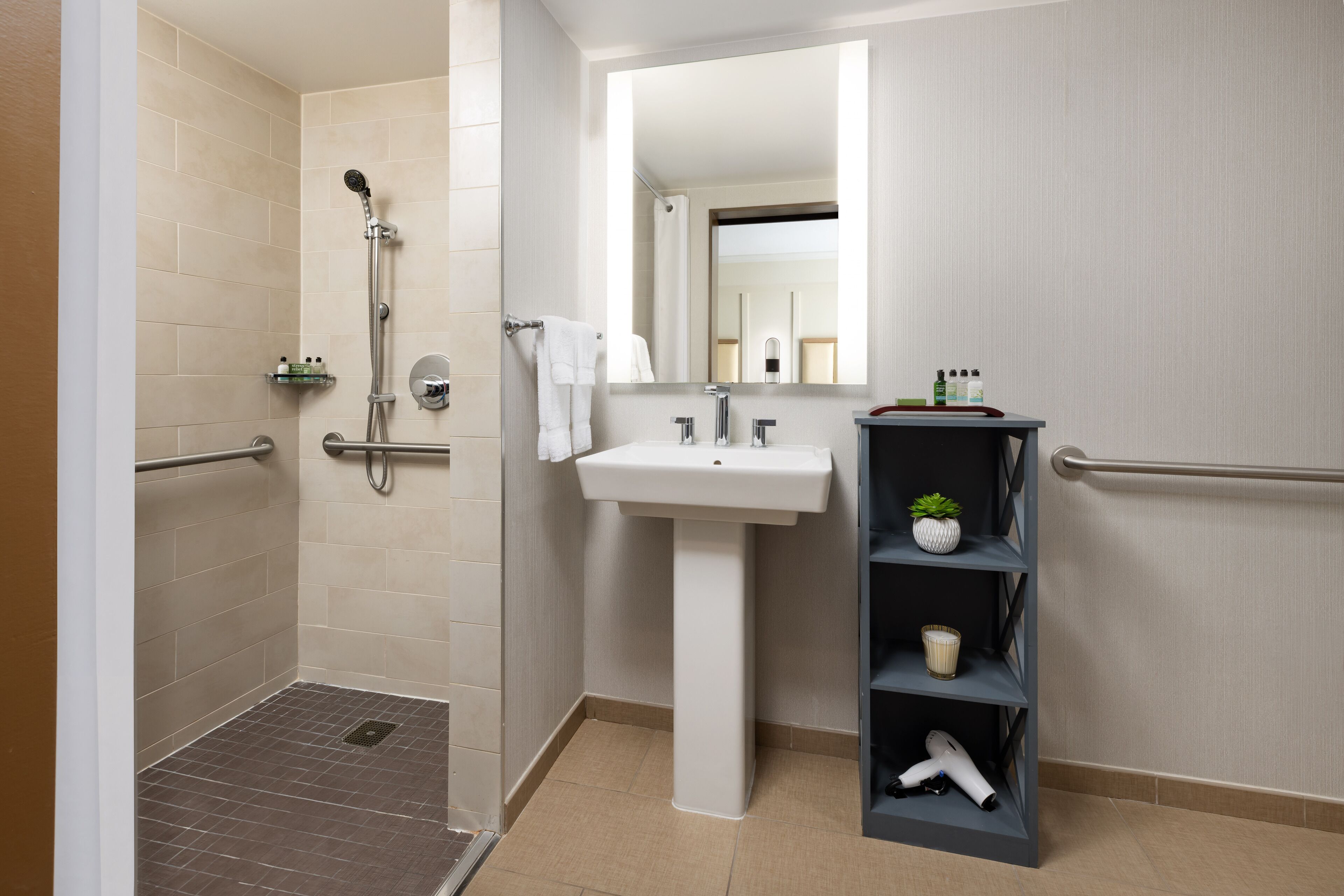 Een moderne badkamer met een douche, wastafel en een plank met toiletartikelen.
