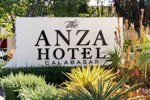 Segnale per The Anza Hotel a Calabasas, circondato da vegetazione.