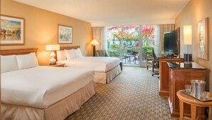 A hotel room with two beds, a desk with a TV, and a balcony with a view of trees. - Hilton Seattle Airport & Conference Center (SeaTac)