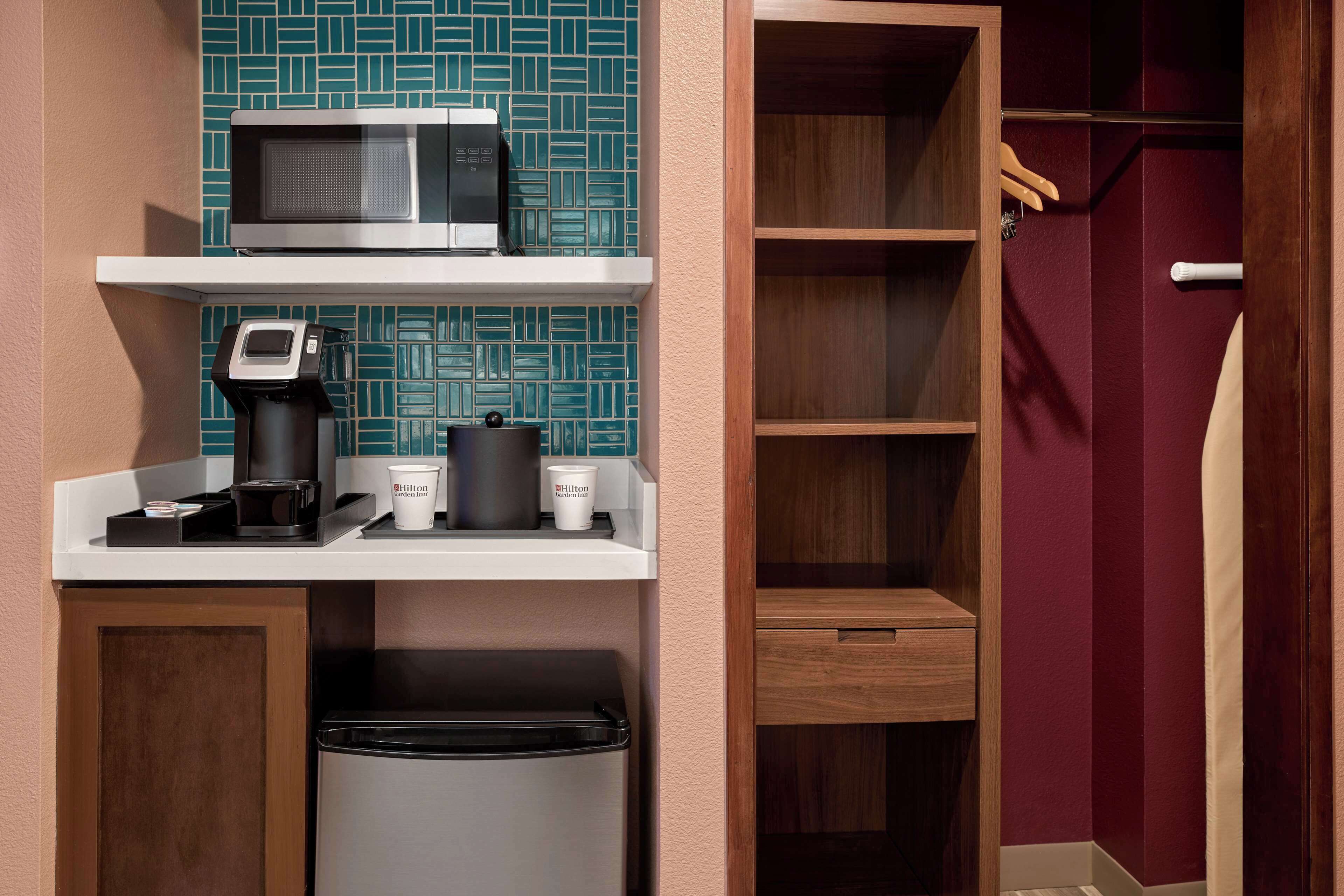 Une petite cuisine équipée d’un four à micro-ondes, d’une machine à café et de récipients de rangement.