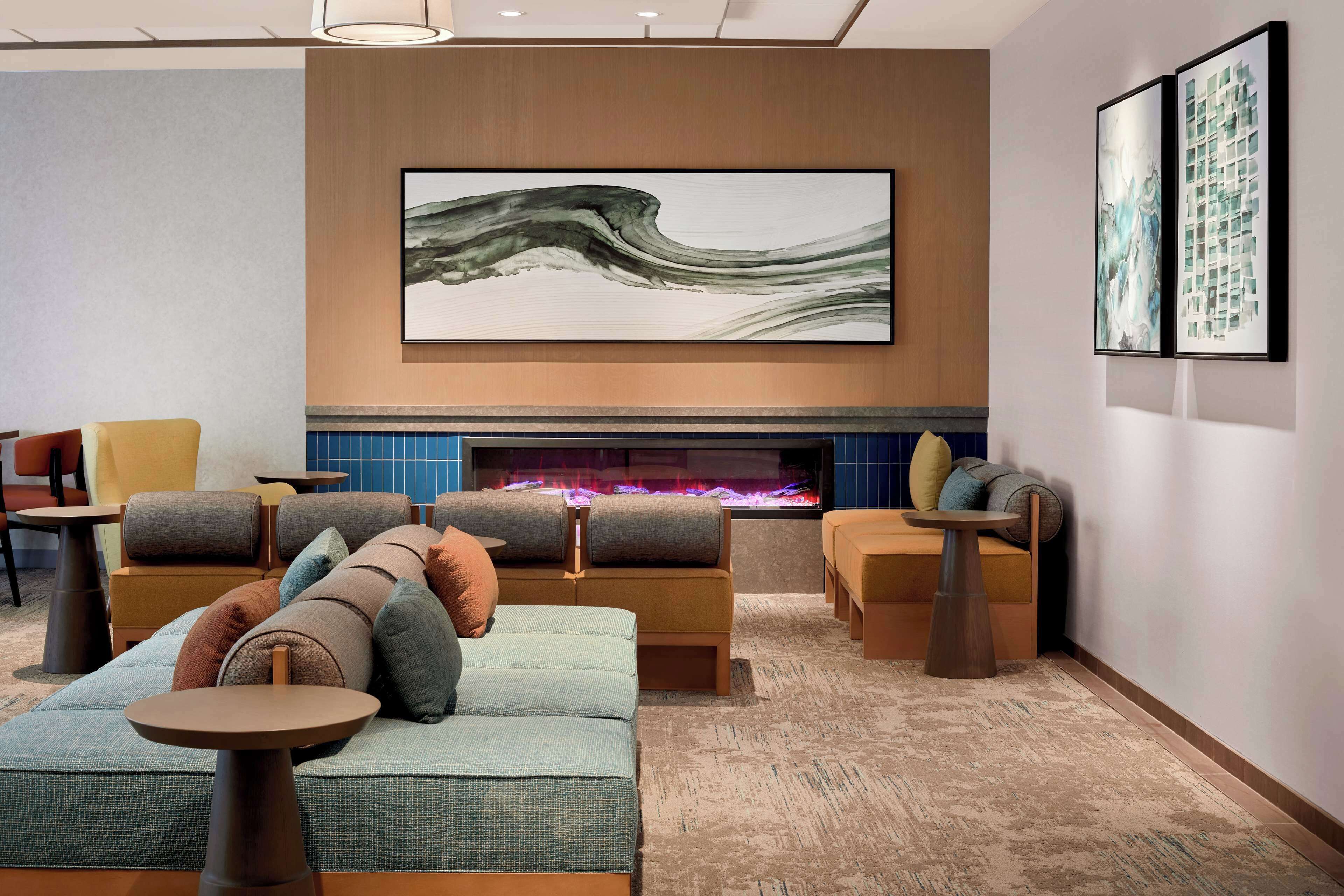 A modern lounge area with sofas, armchairs, and a fireplace.