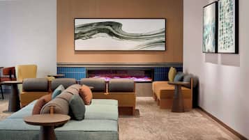 A modern lounge area with sofas, armchairs, and a fireplace.