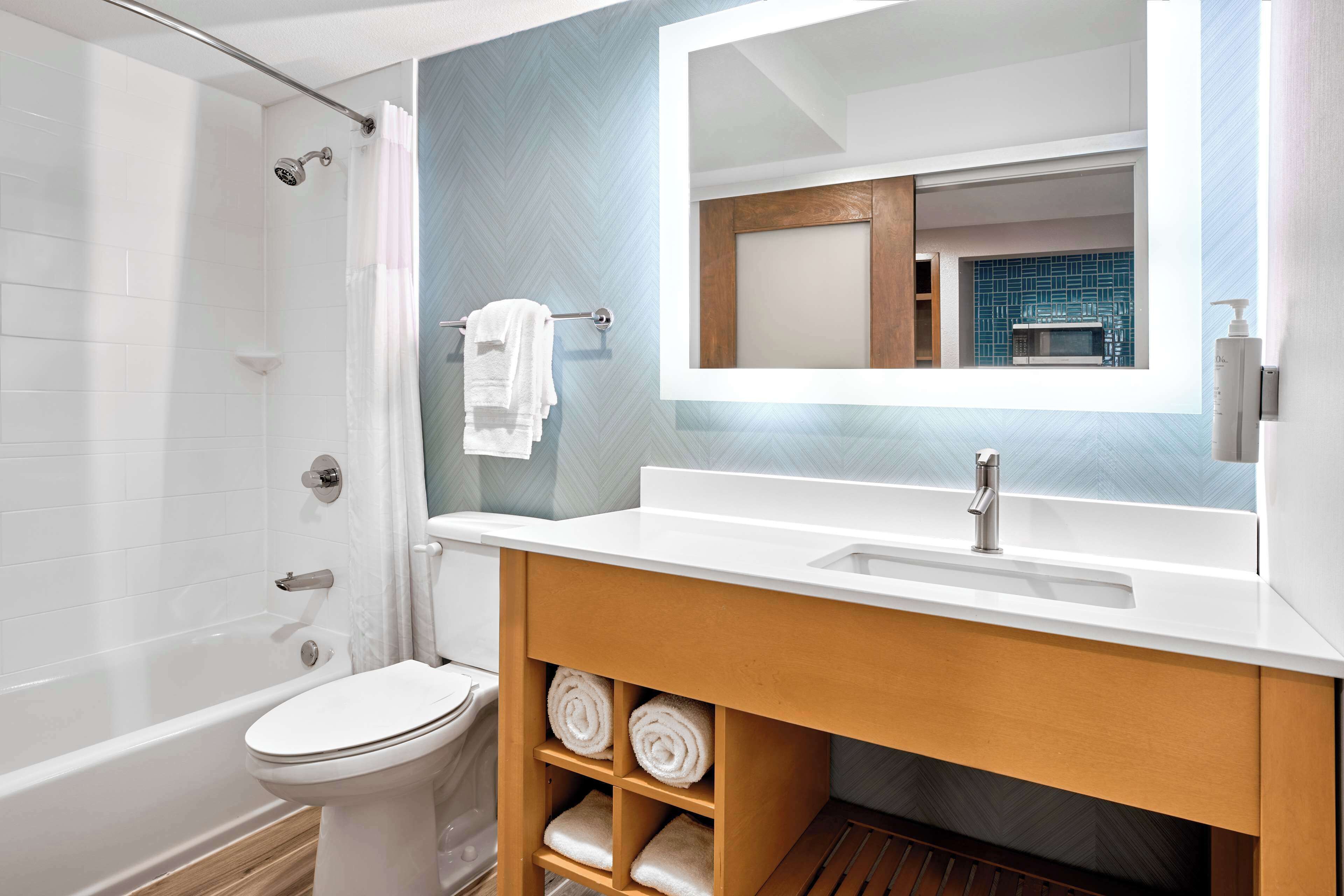 Un baño moderno con ducha, inodoro y lavamanos.