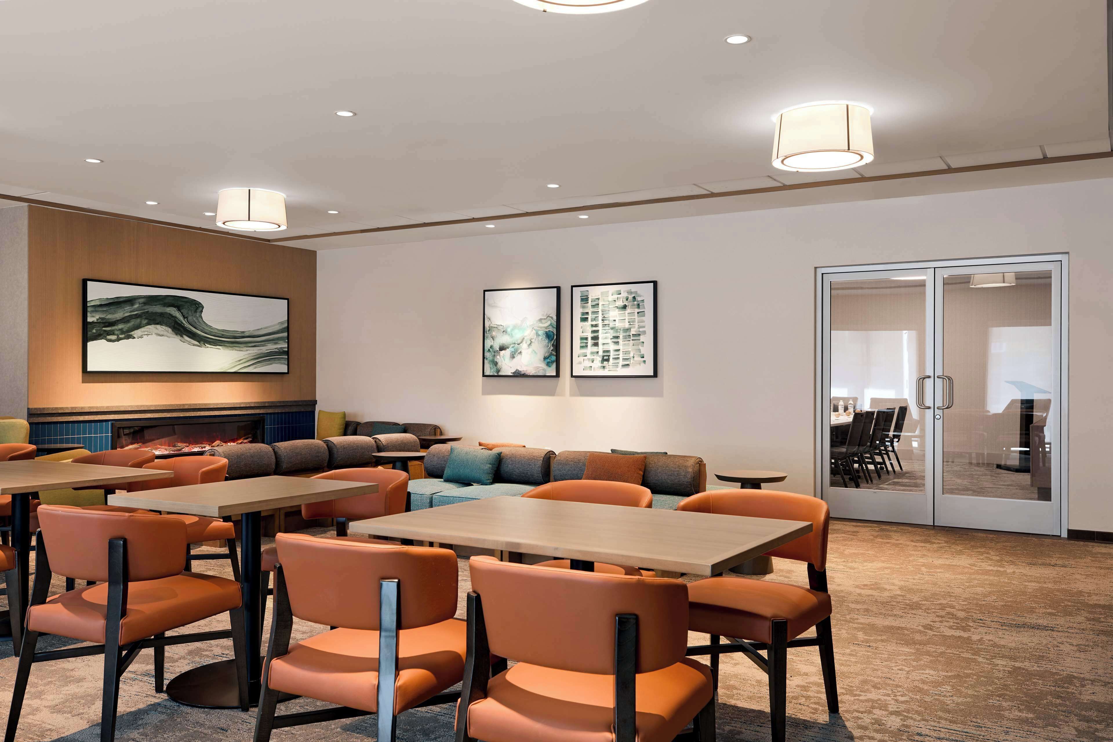 En moderne hotellobby med siddeområder, borde og kunst på væggene.