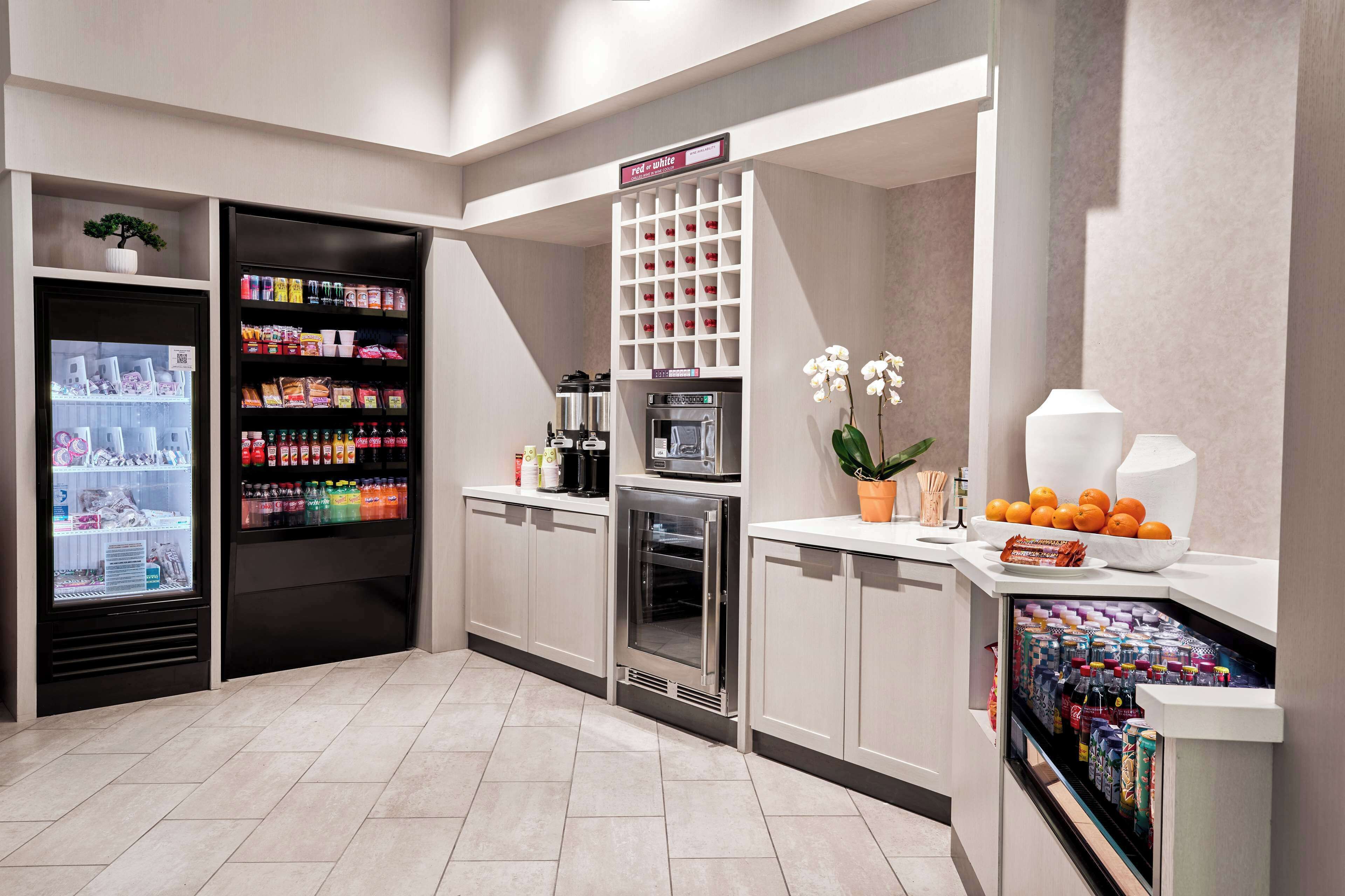 A modern kitchen with a refrigerator, microwave, and a coffee machine.