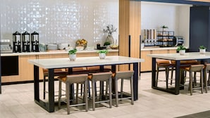 Una cocina moderna con una isla central, taburetes de bar y una estación de café.