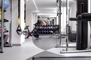 Une salle de sport moderne équipée de matériel d’exercice, d’une série de haltères et d’un vélo d’appartement.
