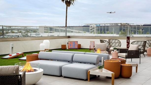 Terraza en la azotea con un brasero, asientos y vistas de un avión.