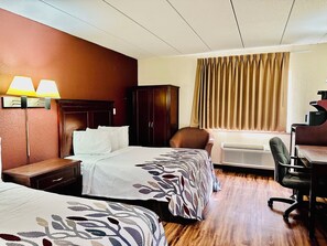 A hotel room with two beds, a desk, an air conditioner, and a chair. - Red Roof Inn Hartford - Vernon (Vernon)