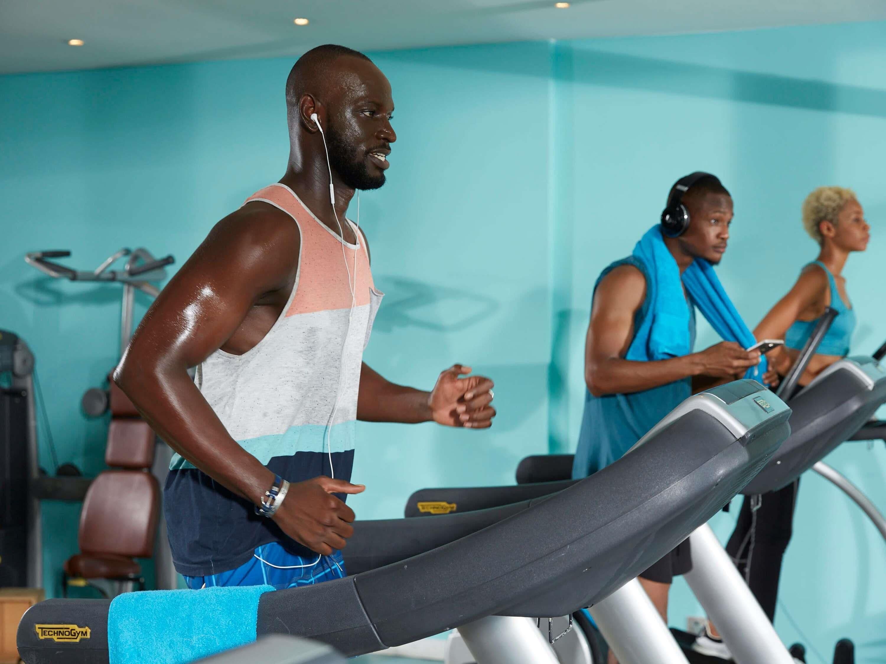 Et fitnesscenter med løbebånd og træningsudstyr.