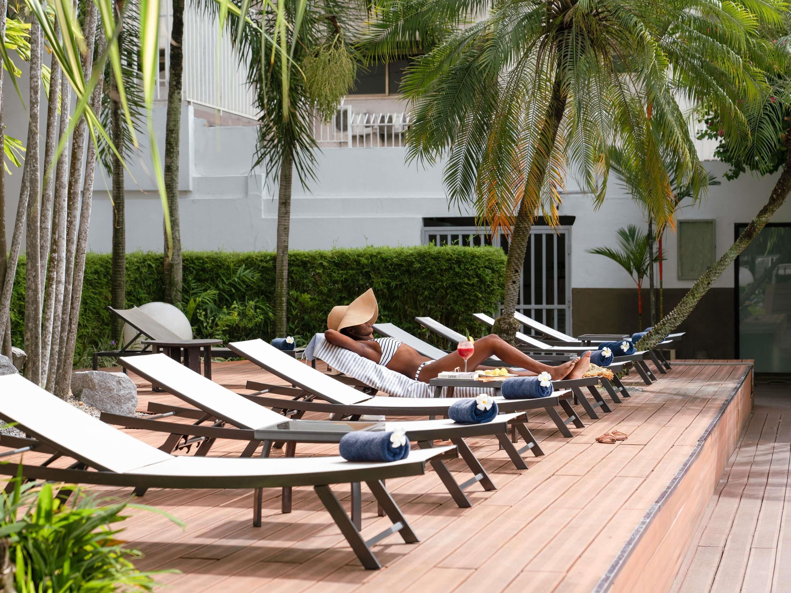 Una piscina al aire libre, tumbonas