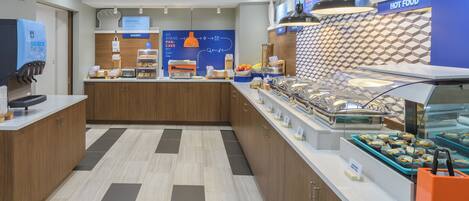 A breakfast area with a self-serve station, a bakery section, and a display of hot food.