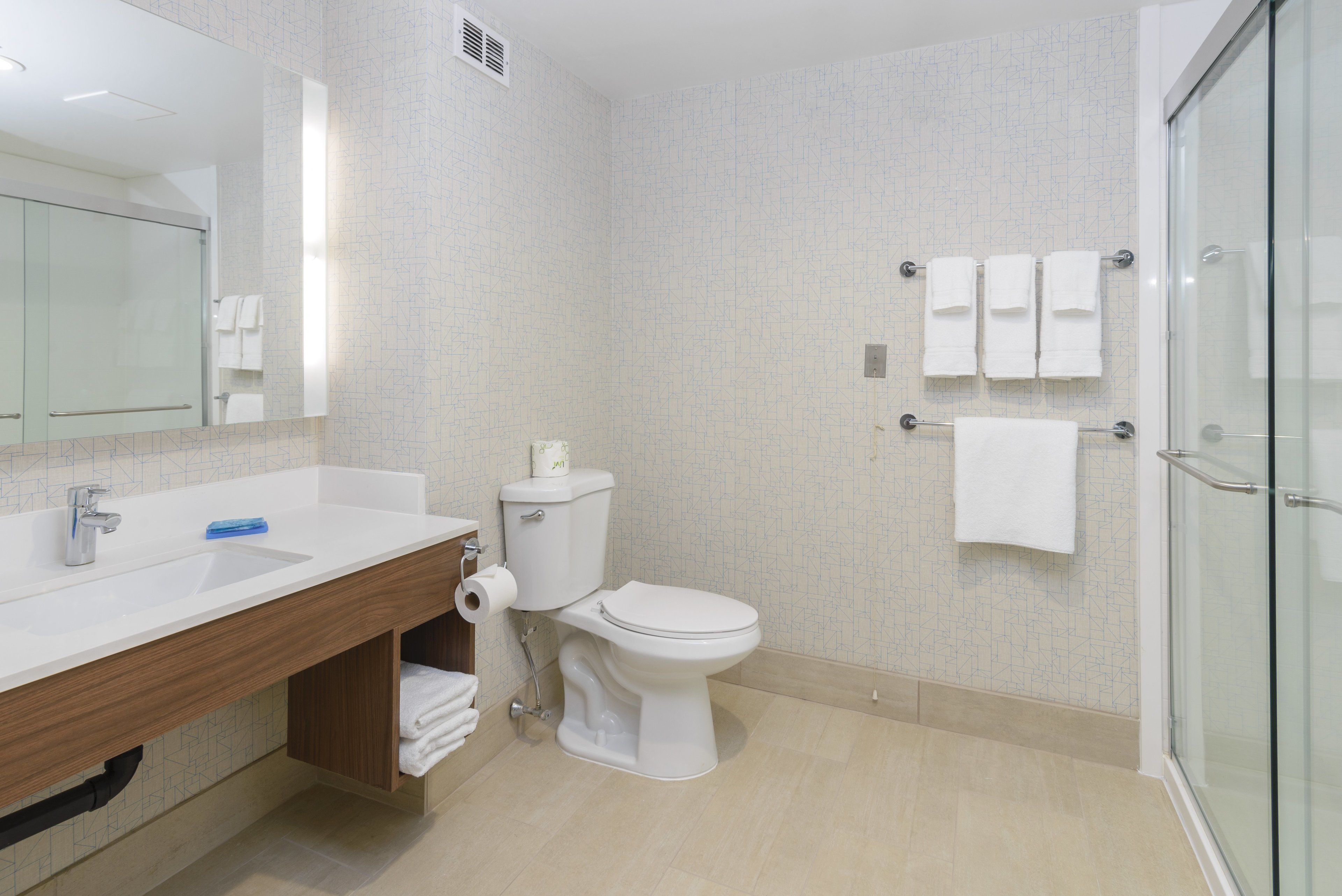 A modern bathroom with a white sink, toilet, and shower.