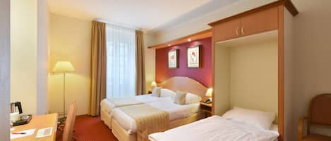 Une chambre d’hôtel avec deux lits, un bureau, une chaise, une lampe et une armoire.
