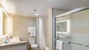 A modern bathroom with a glass shower enclosure, a toilet, and a sink with a mirror.
