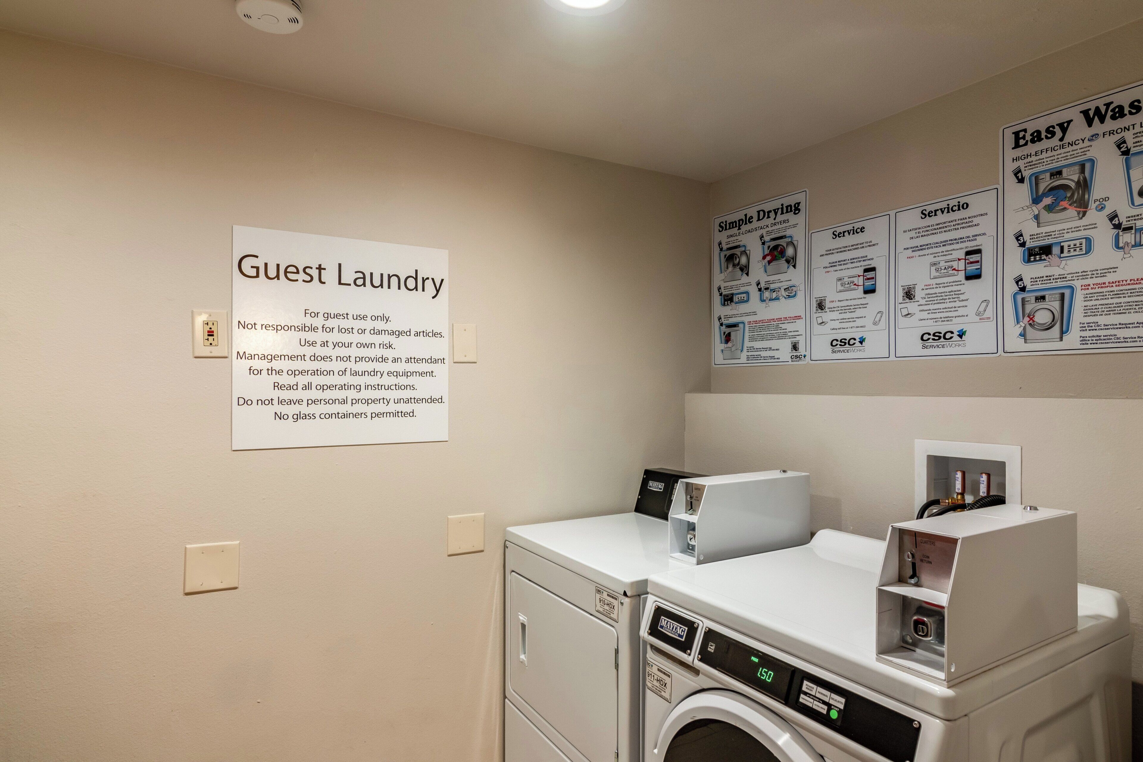A guest laundry area with a sign indicating it's for guest use only, a washing machine, and a dryer.