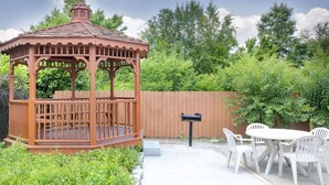 A wooden gazebo with a tiled roof, surrounded by a wooden fence and greenery. - Days Inn by Wyndham Columbus-North Fort Moore (Columbus)