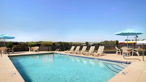 A clear blue pool with lounge chairs and umbrellas, surrounded by a fence. - Days Inn by Wyndham Columbus-North Fort Moore (Columbus)