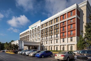 A Holiday Inn Express hotel with a parking lot full of cars. - Holiday Inn Express Atlanta Airport - College Park by IHG (College Park)