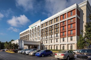 Un hotel Holiday Inn Express con un estacionamiento lleno de coches.