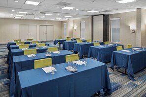 A conference room with multiple tables, chairs, and a carpeted floor. - Holiday Inn Express Atlanta Airport - College Park by IHG (College Park)