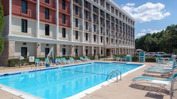 Una piscina al aire libre, tumbonas