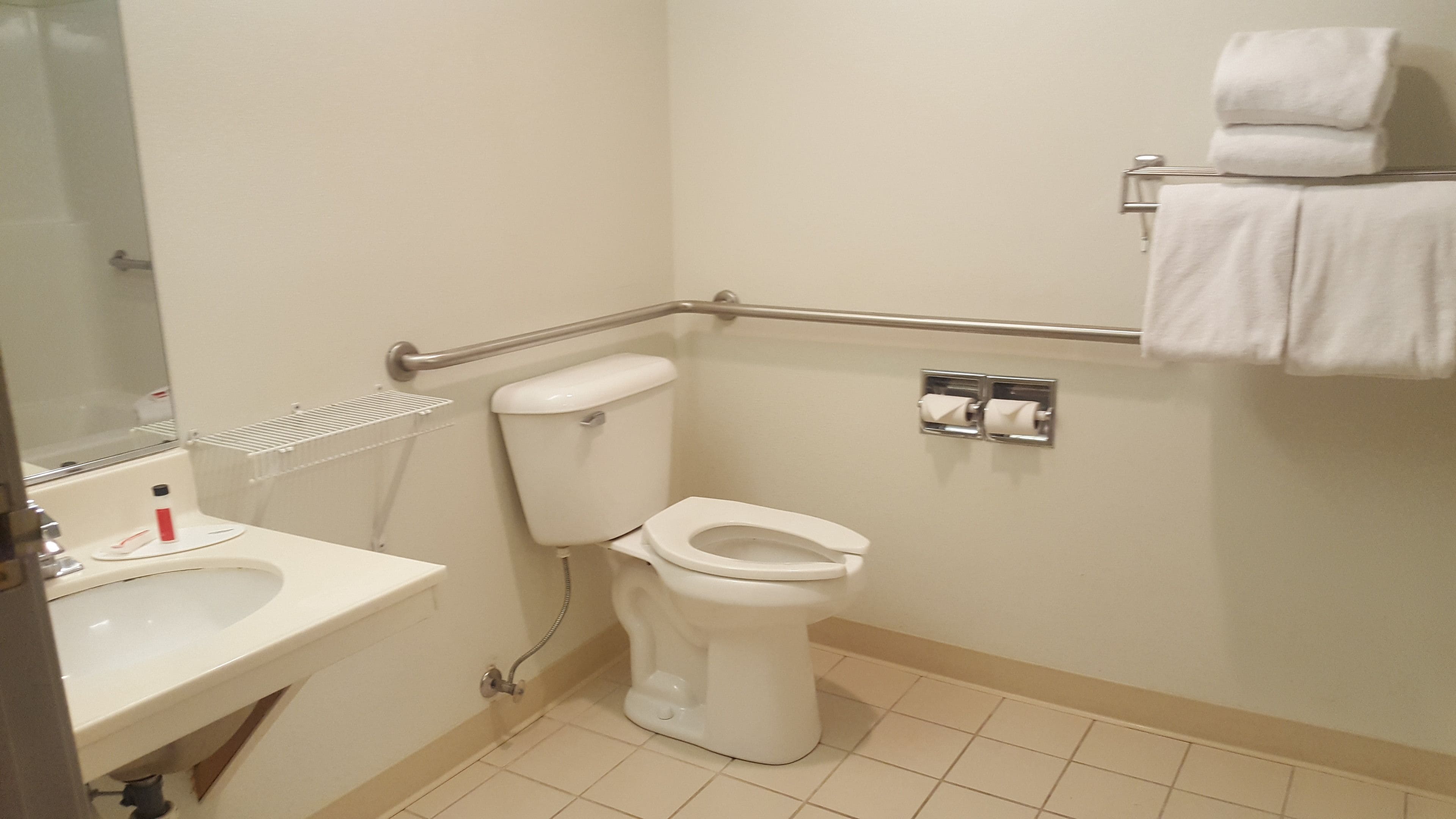 A small, clean bathroom with a toilet, sink, and hand dryer.
