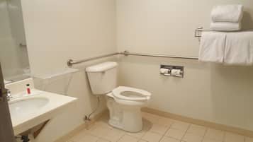 A small, clean bathroom with a toilet, sink, and hand dryer.