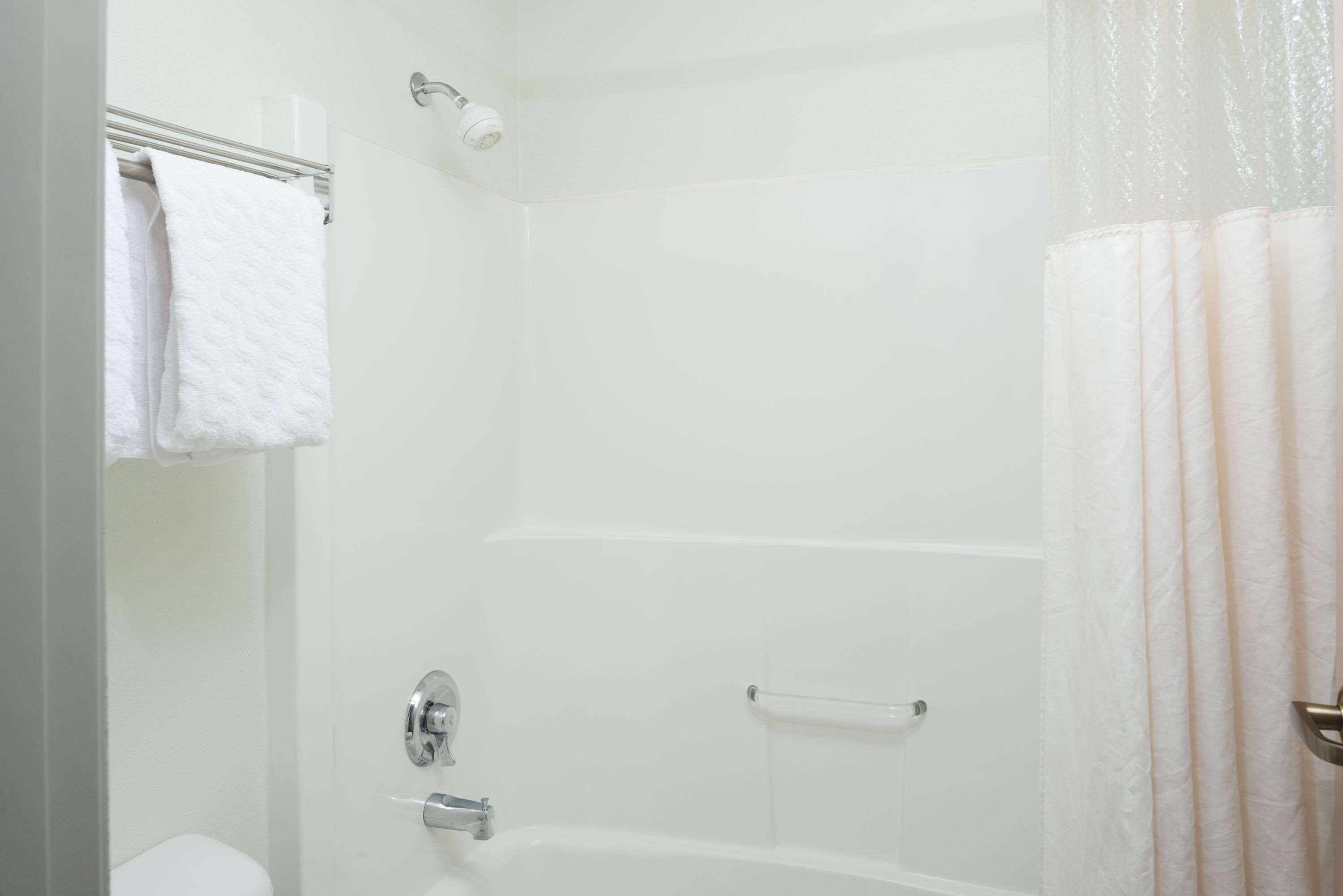 Une salle de bain équipée d’une douche, de toilettes et d’un porte-serviettes.