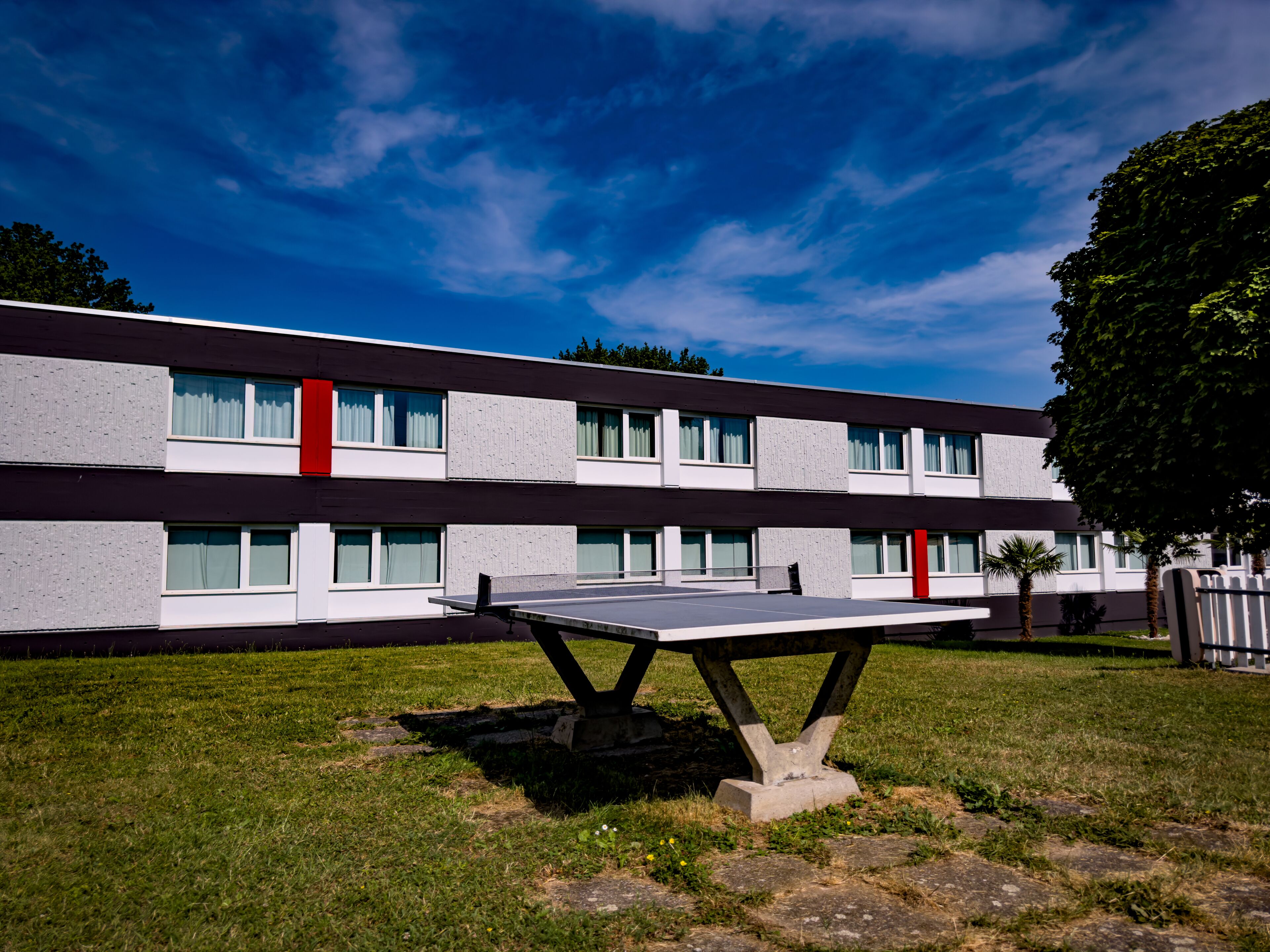 A modern building with a flat roof, large windows, and a flat facade.