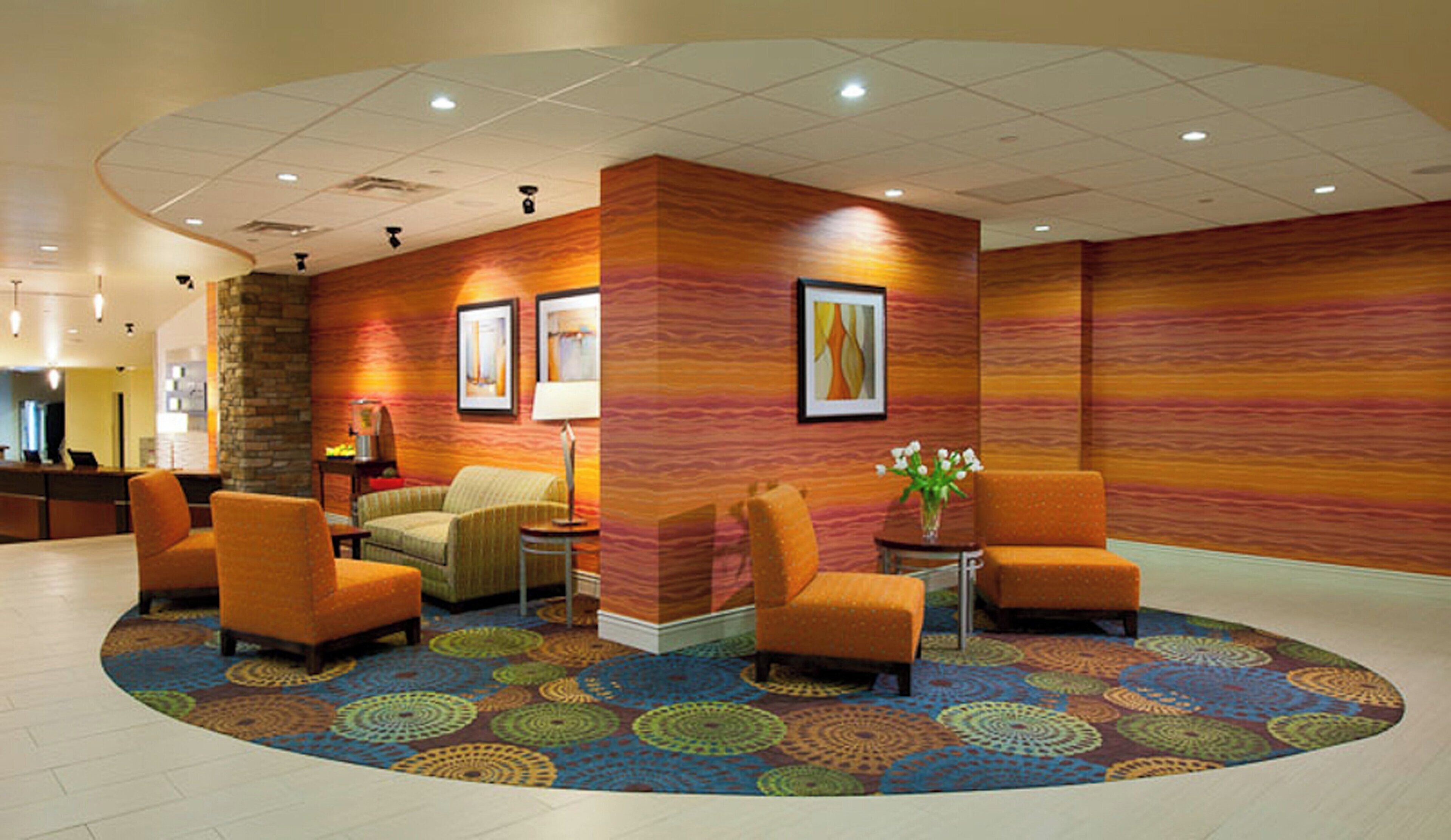 A lobby with a reception desk, seating area, and a patterned carpet.