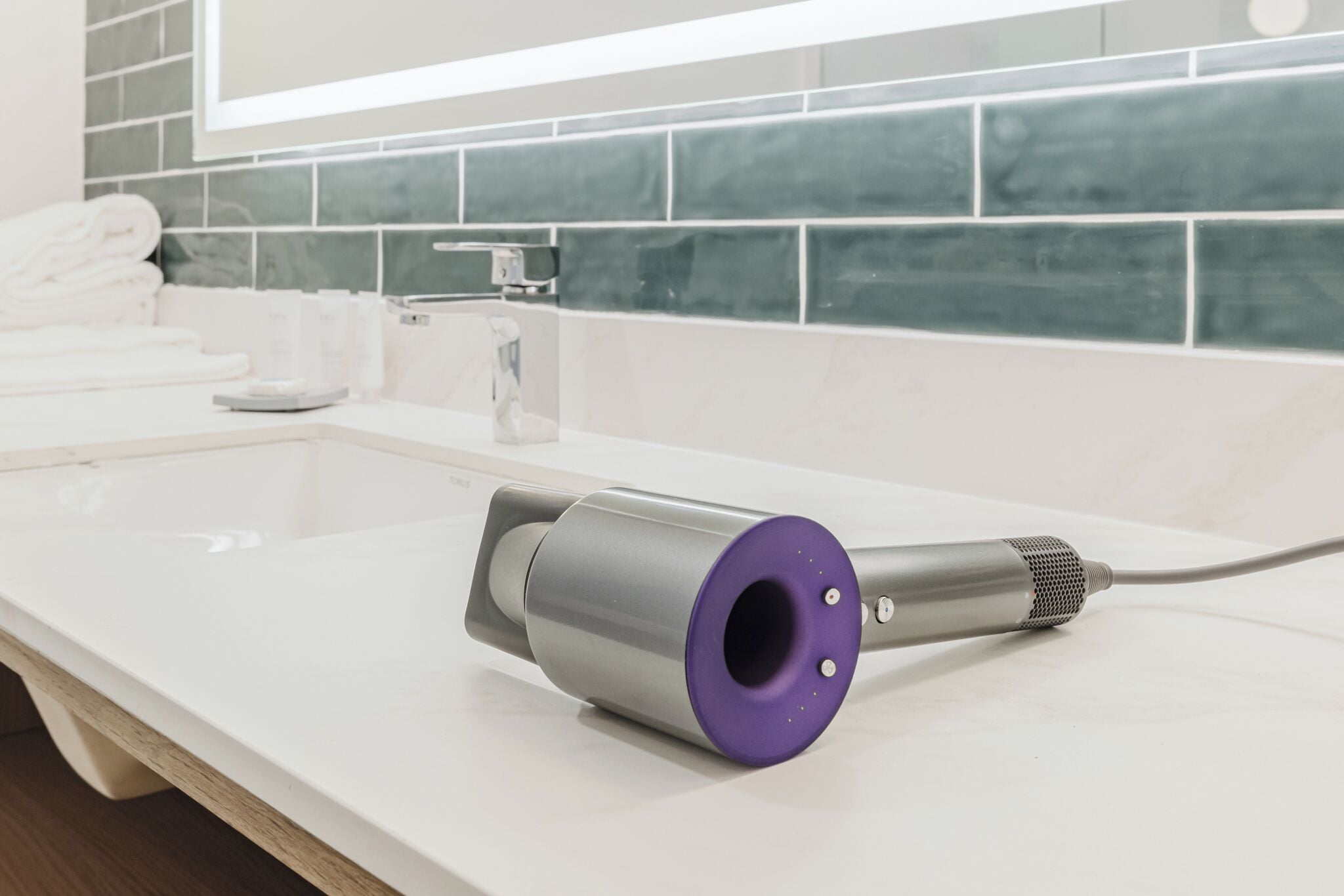 A bathroom with a white countertop, a towel rack, and a mirror.