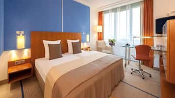 Luxe beddengoed, een kluis op de kamer, een bureau, een laptopwerkplek