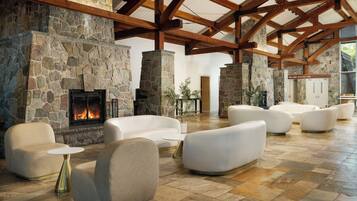 Una chimenea de piedra, sofás blancos y un cartel que dice 'Grand Ballroom'.