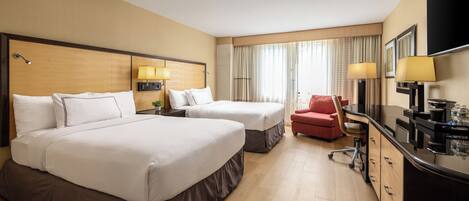 A hotel room with two beds, a desk, a chair, and a TV.
